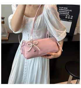 Detail van roze okseltas in Koreaanse stijl met een strik van parels en kant.