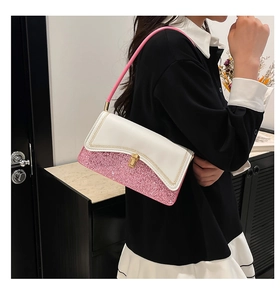 Detail of pink and white shoulder bag featuring glitter material and gold clasp lock