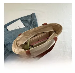 Detail view showing large capacity and zipper closure of straw woven tote bag