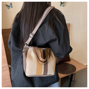 Vertical striped canvas tote bag with long adjustable strap shown in a casual interior