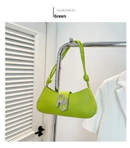 Détail du sac sous le bras en cuir vert néon avec boucle en métal argenté et bandoulière nouée
