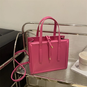 Elegant magenta tote bag with knot drawstring and gold metal accents for urban fashion