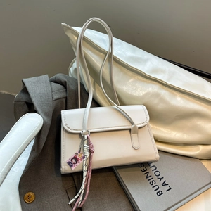 Minimalist beige leather shoulder bag with decorative tassels for women's daily commute