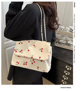Détail du sac cabas en velours côtelé écru avec broderies cerises et bandoulière chaîne