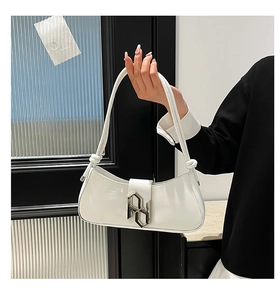 Détail du sac demi-lune blanc brillant avec fermoir géométrique argenté et bandoulière nouée