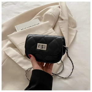 Gros plan sur le mini sac matelassé noir avec fermoir rotatif argenté et bandoulière chaîne
