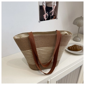 Close-up of striped straw tote bag showing woven texture and long brown handles