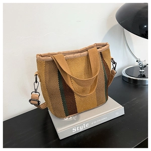 Détail d'un sac cabas en maille à rayures avec bandoulière beige réglable et amovible