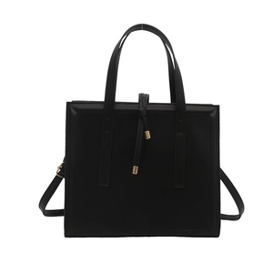 Minimalist black square leather handbag with gold metal accents and crossbody strap