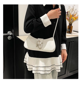 Gros plan d'un sac demi-lune en cuir PU blanc avec boucle logo géométrique argentée