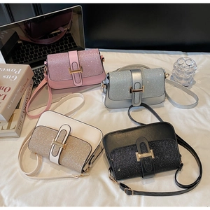 Close-up of stylish sequined crossbody bags in pink, silver, white and black colors