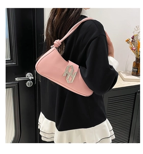 Détail du sac sous le bras en cuir PU rose avec logo argenté et bandoulière nouée