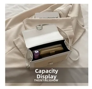 Detail view of contrast stitching handbag with silver lock showing spacious interior storage