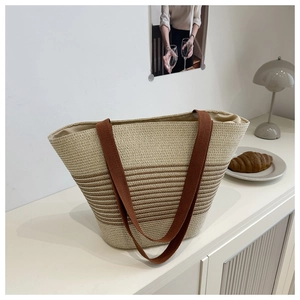 Detail of hand-woven straw tote bag featuring brown stripes and large capacity texture