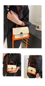 Detail view of woven fabric crossbody bag with orange leather trim and silver clasp
