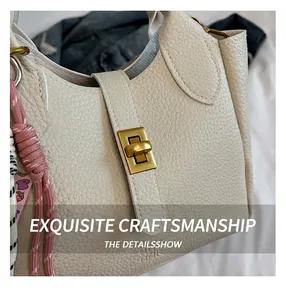Close-up of cream lychee grain leather bucket bag with gold turn-lock closure