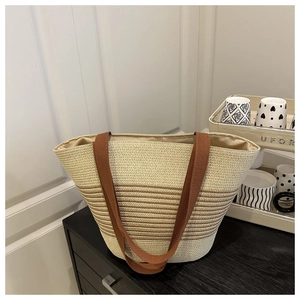 Detailed view of cream and brown woven tote bag with stripe patterns and soft texture