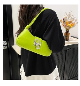 Détail du sac sous le bras en cuir verni vert fluo avec boucle métallique argentée