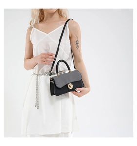 Mannequin portant un sac bandoulière noir et gris chic avec fermoir doré