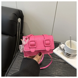 Detailed view of pink mini crossbody bag with carbon fiber texture and acrylic chain