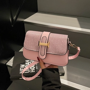 Pink leather shoulder bag with glitter top flap and golden H buckle on urban stairs
