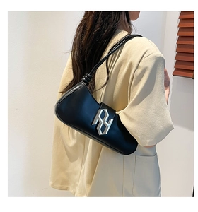 Détail du sac baguette en PU noir avec boucle argentée et bandoulière à nœud décoratif