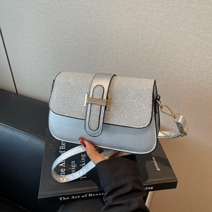 Silver rhinestone crossbody bag with a gold H-shaped buckle shown in hand