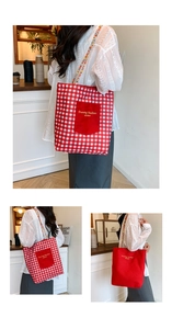Detailed view of canvas tote bag featuring red checkered patterns and woven handles