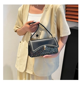Close-up of contrast stitching and gold metal clasp on a sequined retro handbag