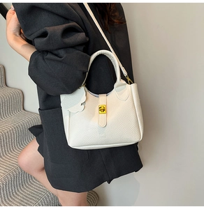 Detailed close-up view of a white lychee grain bucket bag featuring a gold clasp