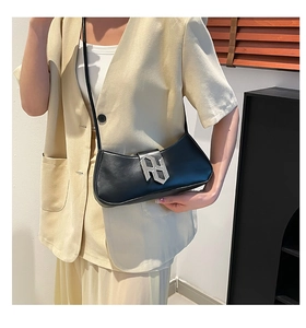 Détail du sac croissant noir avec une grande boucle géométrique en métal argenté