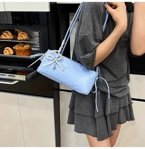 Detailed view of light blue sweet style underarm bag with pearl bow and white lace