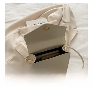Detail view of the warm beige flap bag showing internal capacity with phone and wallet