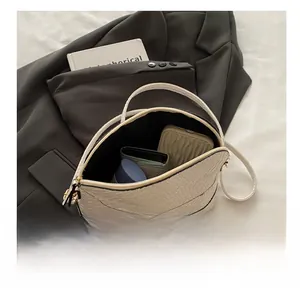 Vue intérieure du sac coquillage blanc tressé montrant sa capacité de rangement