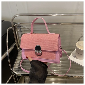Detail of pink leather handbag showing woven texture and silver circular twist lock