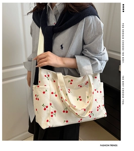 Détail du sac cabas en velours côtelé beige avec imprimés cerises et poche latérale