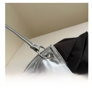 Detailed close-up of metallic silver bag showing the polished ring strap connector