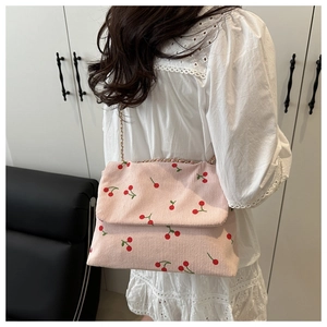 Détail du sac fourre-tout en velours côtelé rose avec motif cerise et chaîne dorée