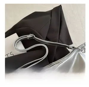 Detail of ergonomic wide handle on silver metallic leather tote bag with glossy finish