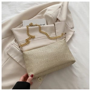 Détail du sac à bandoulière tissé beige avec une élégante bandoulière en chaîne dorée