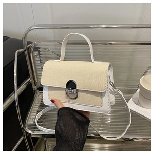 Detail of a chic contrast stitching small square bag with silver rotary lock and woven panel