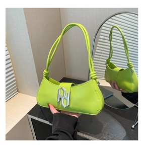 Détail du sac sous le bras en cuir PU vert citron avec nœud et logo argenté