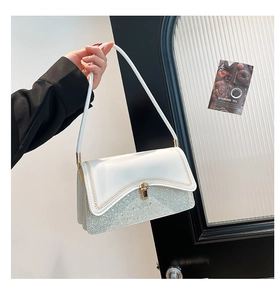 Detailed view of the gold rotary lock and sequined stitching on the chic shoulder bag
