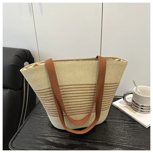 Detailed close-up of woven cotton rope tote bag with brown stripes on a wooden table