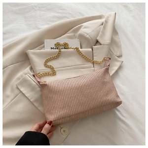 Détail du sac à bandoulière tressé beige avec sa chaîne dorée épaisse élégante