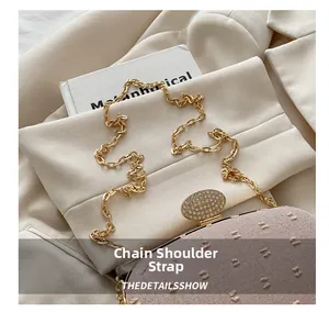 Detailed view of the gold thick chain strap and rhinestone oval buckle on the pink beige bag
