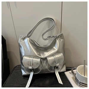 Macro detail of metallic silver tote bag with utilitarian pockets and buckles