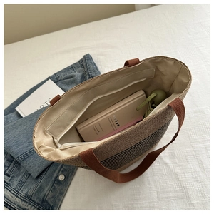 Interior detail of woven tote bag with zip pocket showing capacity for laptop and umbrella