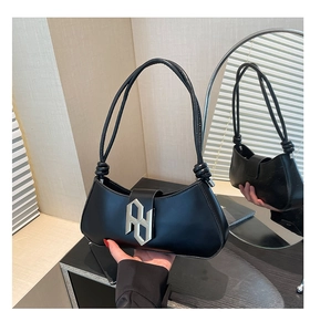 Détail du sac sous le bras en similicuir noir avec boucle métallique géométrique