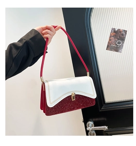 Detail of red and white shoulder bag with sequins, wavy stitching and gold buckle